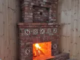 Угловой камин с открытой топкой из старинного кирпича